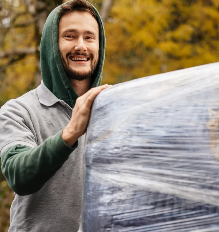 Ivan Gilyov, founder of Mount Si Movers, carrying wrapped furniture